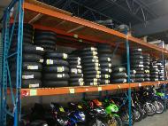Stacks of tires sitting on shelves about motorcycles