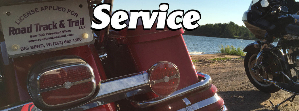 A car and a motorcycle parked side by side on a sunny day next to a lake.