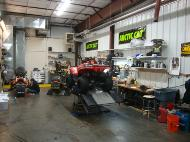 An ATV sitting on a lift in a service garage